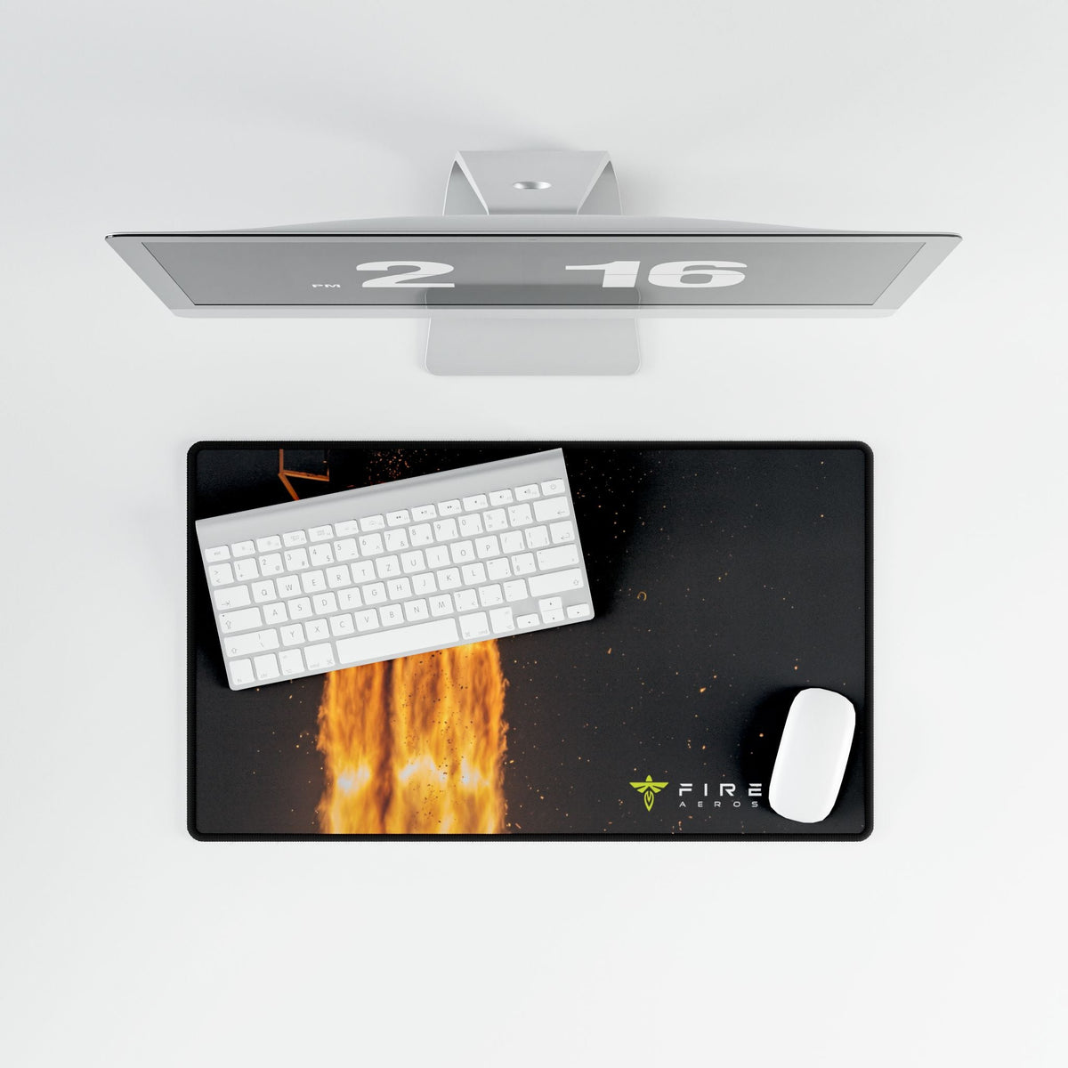 A black desk mat with a fiery graphic and the FIVE FIRE logo, styled with a white keyboard and mouse on a white surface under a silver monitor.