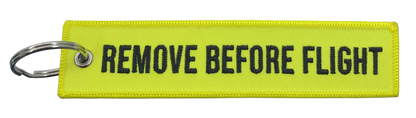 Yellow keychain with 'REMOVE BEFORE FLIGHT' text on a white background